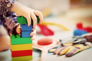 Imagem descrição - criança brincando com blocos coloridos